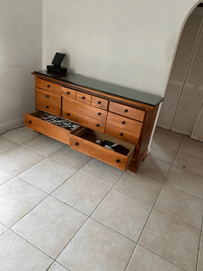 Wooden bedroom dresser with open drawers before furniture removal and cleanout