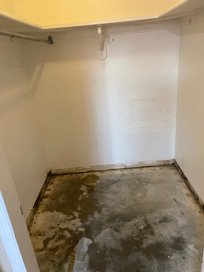 Closet area cleared with concrete floor and wall shelving visible