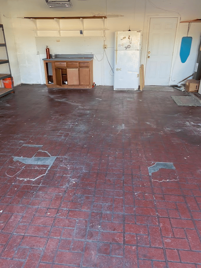 Open garage interior with cabinets, shelving, and cleared floor area