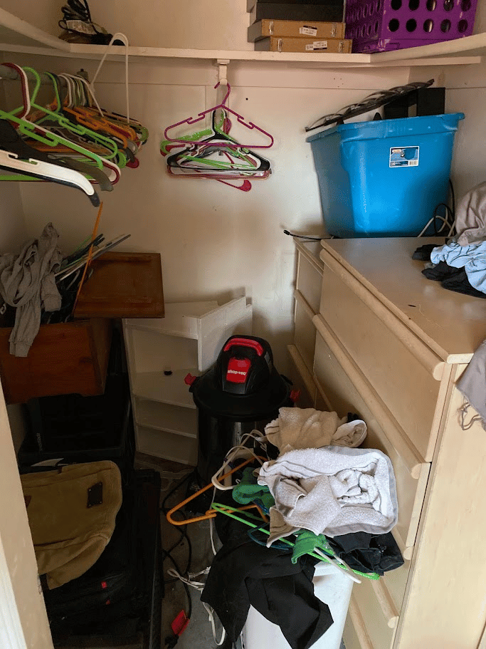 Closet packed with clothes hangers, dresser drawers, storage bins, and household clutter