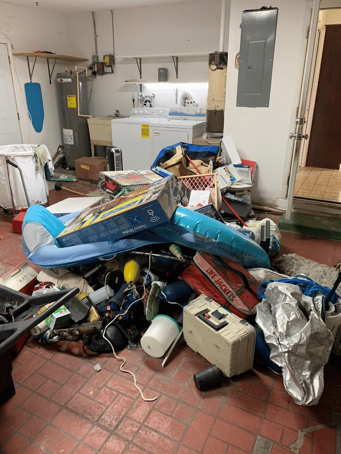 Garage utility area with assorted household items and bulky materials gathered for removal