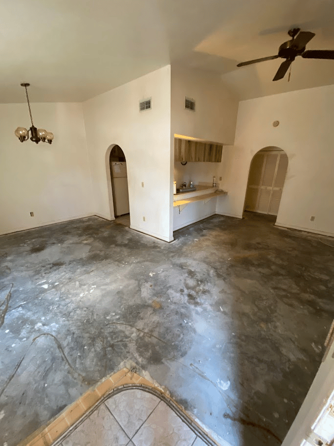 Living room cleared after flooring removal and interior cleanout