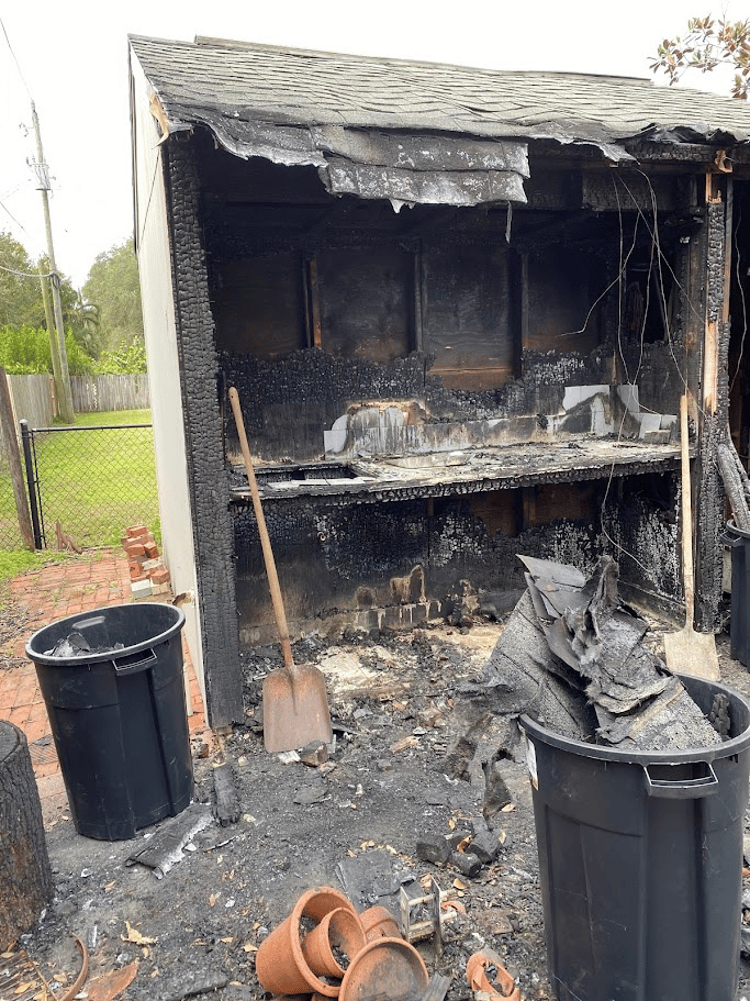 Charred interior of a small structure following fire damage