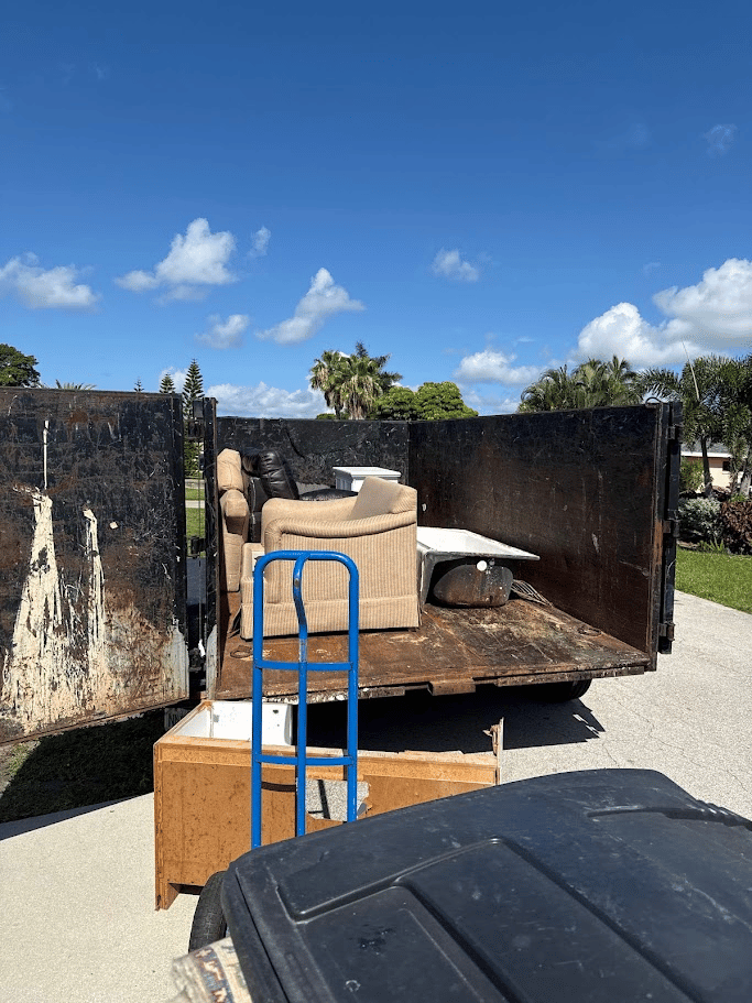 Furniture junk removal with couch and household items loaded into trailer by Pure Disposal