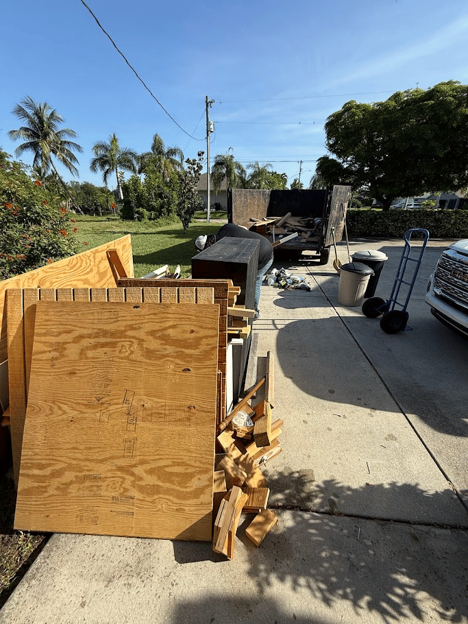 Wood debris and construction junk pickup on driveway by Pure Disposal
