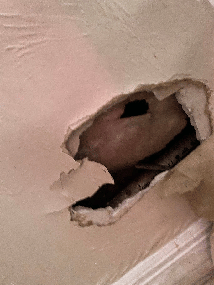 Close-up of a small opening in an interior drywall surface
