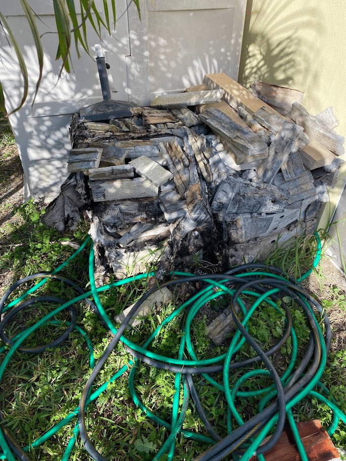 Weathered wood pieces and boards stacked beside an exterior wall