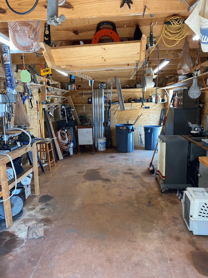 Spacious garage workshop with organized tools, shelves, and clear floor after cleanout